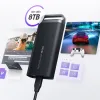 Bên trái của một chiếc laptop đang mở với hình ảnh phóng to phía trên hiển thị một cặp đôi đang đi xe đạp dọc theo một thềm gỗ trong phần mềm chỉnh sửa video. Bên phải là một trò chơi đua xe ô tô và một bộ điều khiển trò chơi PC. Chúng được chia đôi bởi T5 EVO với văn bản "Lên đến 8TB" được viết ở góc trên bên trái.